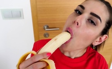 Cute girl eats a banana and fingers herself